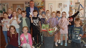 Viele Kinder und ein Erwachsener stehen in einer Gruppe zusammen.
