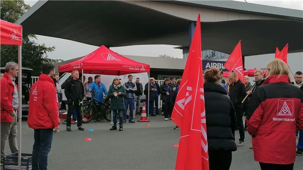 Menschen stehen vorm Airbus-Tor in Nordenham.