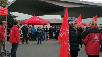 Eine Menge von Menschen steht vor dem Airbus Werktor in Nordenham.