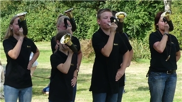 Kinder spielen Jagdhorn.