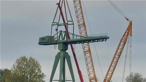 Umsetzung abgeschlossen: Rickmerskran steht wieder sicher Ein gelber Raupen-Kran hebt die Kanzel des historischen grünen Krans auf das Unterteil.