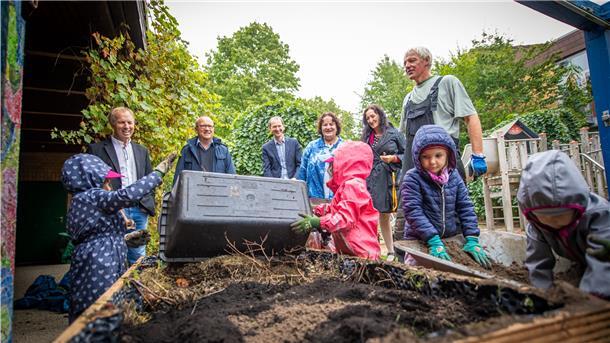 In einer Kindertagesstätte in Bremerhaven helfen Kinder ein Hochbeet anzulegen. 
