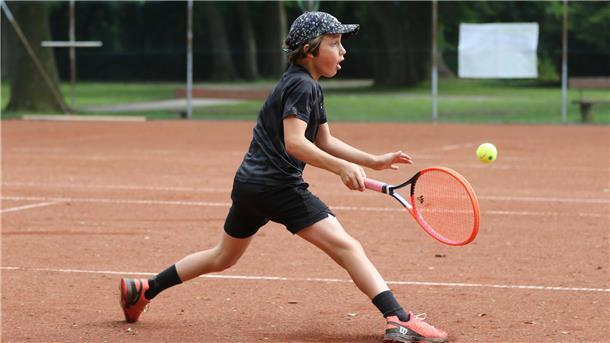 Ein Kind spielt Tennis.