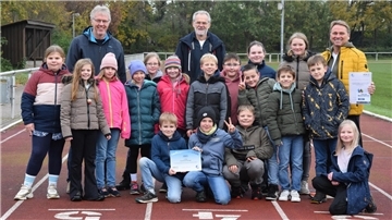 Die Klasse 4b der Grundschule Selsingen nimmt stellvertretend die Plakette und den Gutschein für den Erfolg im AOK-Laufabzeichenwettbewerb entgegen.