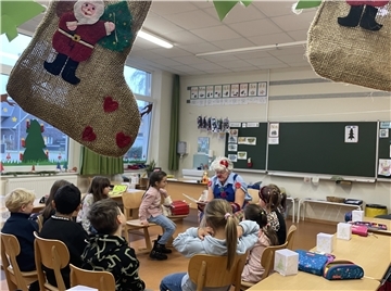 Clownin liest Kindern vor.
