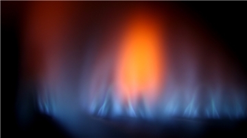 Eine Gasflamme im Sichtfenster eines Gas-Durchlauferhitzers. 