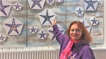 Die Künstlerin Brigitt Hadlich vor ihrer Serie „Nordsee-Sterne“.