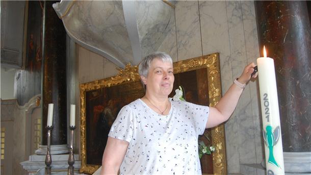 Die gute Seele der Kirchengemeinde Eine Frau entzündet eine Kerze.