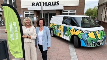 Die Lackierung ist ein Hingucker: Der ID.BUZZ soll in allen 16 Ortschaften der Stadt Geestland über „Smart Cities“ informieren. Projektleiterin Britta Murawski (links) und Bürgermeisterin Gabi Kasten freuen sich auf den Start.