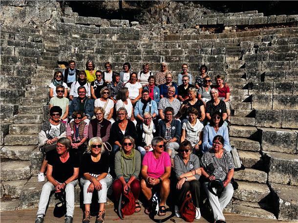 41 Frauen sitzen auf alter Steintreppe.