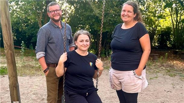 Ein Mann und zwei Frauen an einer Schaukel
