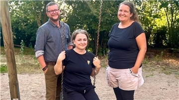 Ein Mann und zwei Frauen an einer Schaukel