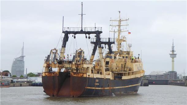 Fischtrawler Nida verlässt Bremerhaven. Im Hintergrund sind der Radarturm und das Atlantic Hotel Sail City zu sehen.