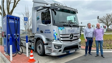Claas Bunjes, Leitung Mobility & Digital Solutions und Ralf Biere, Projektmanagement, stehen vor dem E-Lkw.