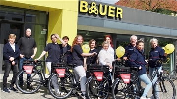 ein Fahrradgeschäft, davor viele Menschen mit E-Bikes
