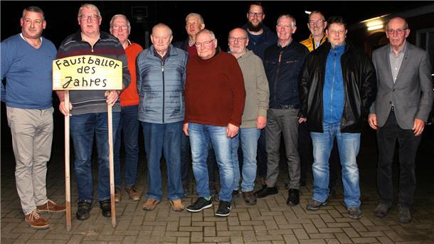 Traditioneller Faustballverein in Butjadingen: seit den 60er Jahren aktiv Zwölf Männer stehen in einer Reihe. Eine hält ein Schild mit der Aufschrift „Faustballer des Jahres“.