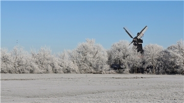 Die Moorseer Mühle in winterlicher Landschaft.
