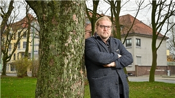Christian Neuhäuser lehnt in Bremerhaven an einem Baum