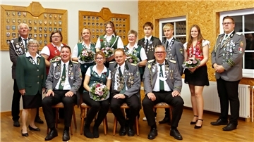 Männer und Frauen in Schützenuniform posieren für ein Foto. 