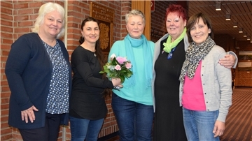 Mehrere Damen stehen zusammen für ein Foto. 