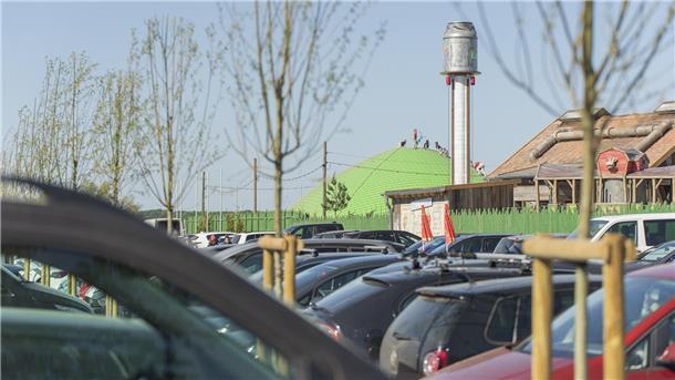 Eröffnung Karls Erlebnis-Dorf: So angespannt war die Verkehrslage Parkplatz vor einem Freizeitpark. Im Hintergrund spielen Kinder auf einer Hüpfburg.