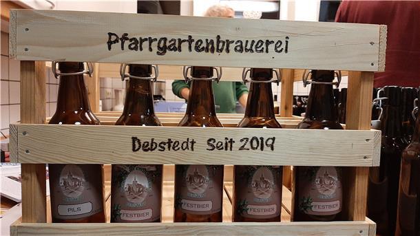 In einer Holzkiste stehen Bierflaschen.