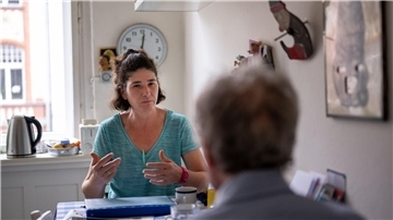 Die Pflegerin Ramona Rössner spricht beim Hausbesuch mit ihrem pflegebedürftigen Patienten Andreas Seltzer.