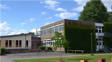 eine Schule mit einem zweistöckigen Gebäude und einem einstöckigen Gebäude