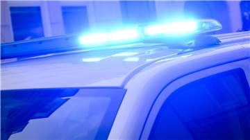 Auf einem Polizeifahrzeug leuchtet ein Blaulicht