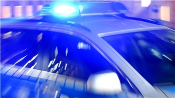 Ein Streifenwagen der Polizei steht mit eingeschaltetem Blaulicht auf der Straße.