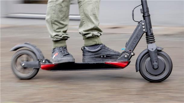  Ein Mann fährt mit einem E-Scooter.