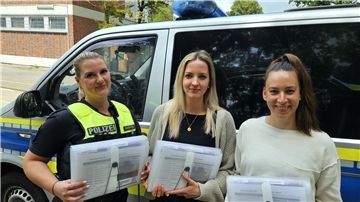 Drei Frauen vor einem Polizeiauto: Die Polizei im Landkreis Wesermarsch ist jetzt mit aktualisierten Info-Mappen zu häuslicher Gewalt ausgestattet. Sie sollen Betroffenen schnell Wege zur Hilfe aufzeigen.
