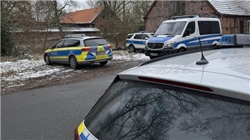 Mehrere Polizeifahrzeuge stehen an einer Straße.