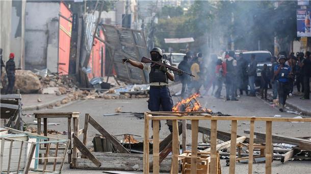 Berichte: Banden greifen Regierungsgebäude in Haiti an Die Polizei sichert eine Straßensperre in Port-au-Prince, die von Demonstranten errichtet wurde.