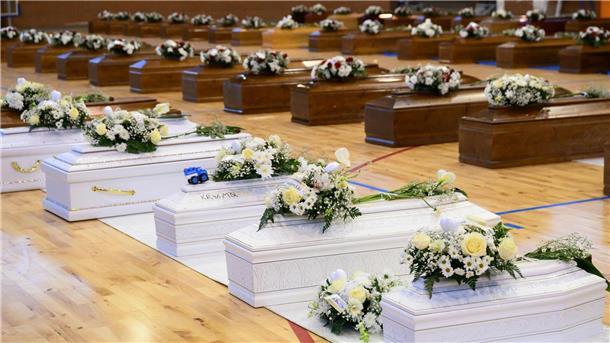 67 Tote nach Bootsunglück - Streit um Rettungseinsatz Die Särge der Opfer des Bootsunglücks stehen mit Blumen bedeckt in einer Sporthalle in Crotone.