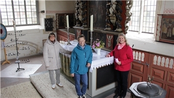 Die Kirchenweiber Monika Heine (von links), Karla Mombeck und Katja Aschen stehen vor dem Altar in der Sankt-Johannis-Kirche Sandstedt. 