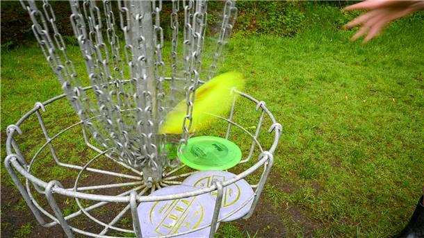 Die neue Trendsportart Discogolf Die Scheibe muss in den Korb