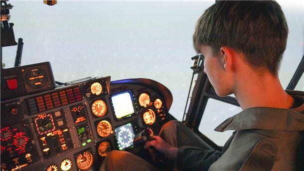 23 Jugendliche erleben bei den Marinefliegern den Alltag in Nordholz hautnah Ein Jugendlicher sitzt in einem realistisch beleuchteten Hubschrauber-Simulator und bedient das Steuer. Vor ihm befinden sich zahlreiche beleuchtete Anzeigen und Instrumente.