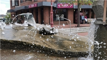 ein Eiscafé, davor ein Wasserspiel