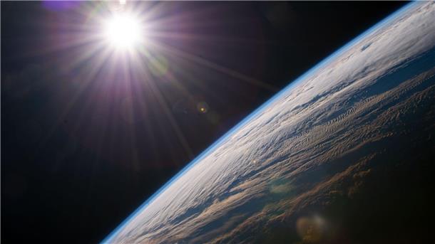 Die Sonne scheint über dem Horizont der Erde, während die Internationale Raumstation über der kanadischen Provinz Quebec kreist.