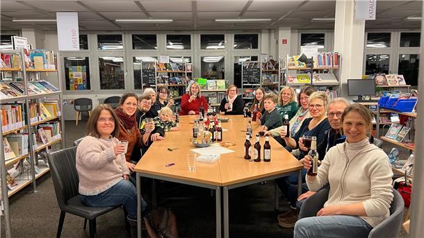 Besucherrekord in der Nordenhamer Stadtbücherei - Das ist ihr Erfolgsrezept Eine große Gruppe sitzt an einem Tisch.