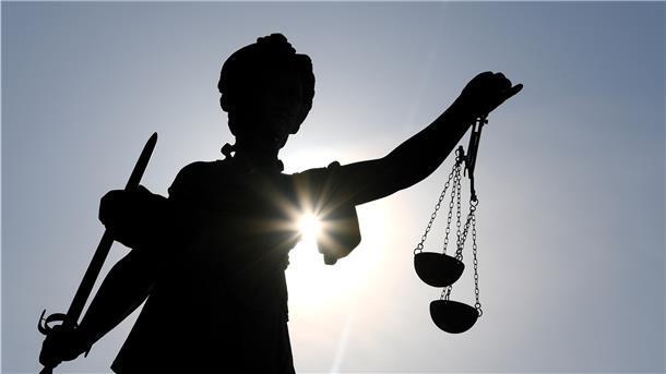 Die Statue der Justitia hält die Waage in der einen und ein Schwert in der anderen Hand.