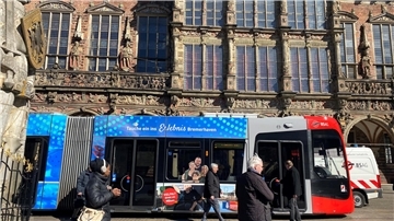 Die Straßenbahn namens „Nordlicht“ fährt mit Bremerhaven-Motiven zwei Jahre lang durch Bremen. Oberbürgermeister Melf Grantz (Mitte) steigt am Bremer Rathaus zur Probefahrt ein. 