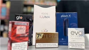 Die Tabakerhitzer-Elektrogeräte der Marken Glo von British American Tobacco (BAT), Iqos von Philip Morris und Ploom von Japan Tobacco International (JTI) mit den dazugehörigen Tabakstick-Marken liegen auf der Verkaufstheke eines Geschäfts.