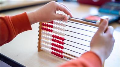 Ein Schüler bedient einen Rechenschieber.