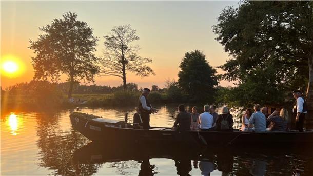 Das Foto zeigt einen Torfkahn bei Sonnenuntergang. 