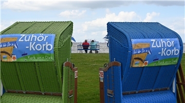 Zwei Strandkörbe mit der Aufschrift "Zuhör-Korb" stehen am Friesenstrand in Tossens.