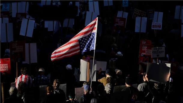 Bilder des Tages Die US-Flagge wird bei einem Demonstrationszug durch Chicago von der Sonne angestrahlt.