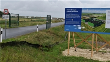 Ein Bauschild steht neben der Zufahrt von der Dedesdorfer Straße zu den Baustellen für die beiden Konverterstationen.