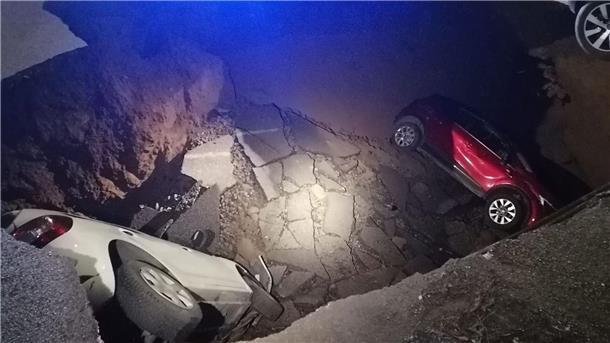 Riesiges Erdloch in Rom verschlingt zwei Autos Die zwei geparkten Autos liegen in dem Erdloch.